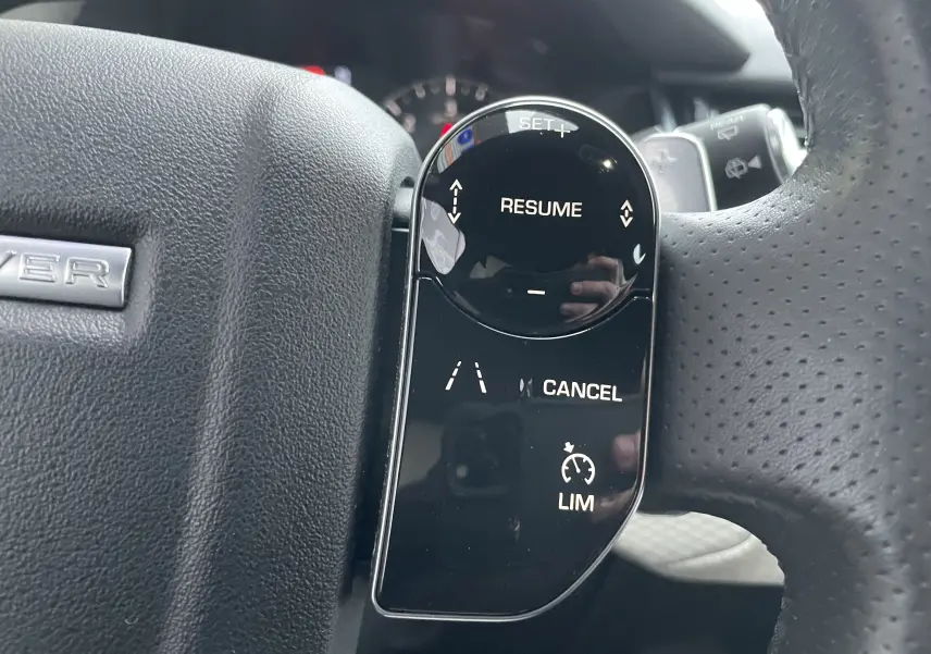 Gros plan sur les commandes au volant côté gauche du Range Rover Velar D300 2018, finition Silicon Silver.