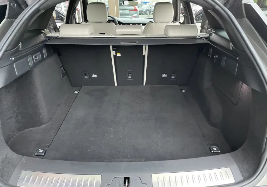 Coffre ouvert du Range Rover Velar D300 2018 en Silicon Silver, montrant l'espace de chargement et les sièges arrière beige.