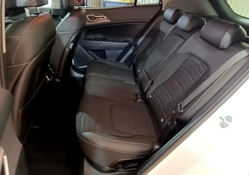 Vue intérieure côté droit des sièges arrière noirs du Kia Sportage blanc 2022, finition Design hybride rechargeable.