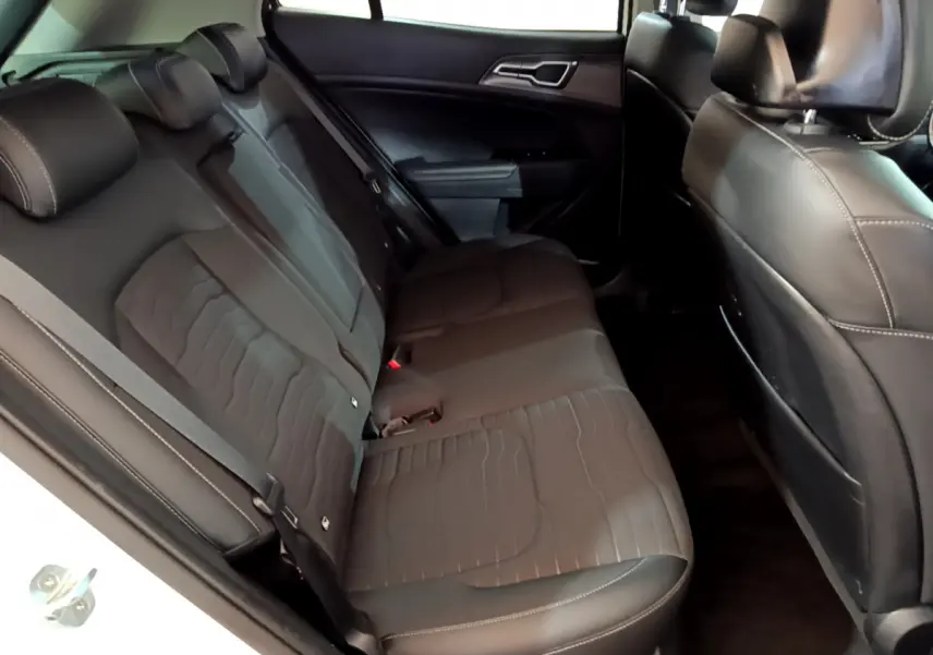 Vue intérieure côté gauche des sièges arrière noirs en cuir du Kia Sportage blanc 2022 hybride rechargeable Design.