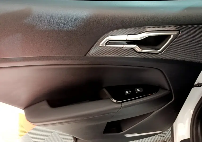 Poignée intérieure et commandes de verrouillage sur la porte côté conducteur d'un KIA SPORTAGE blanc 2022.