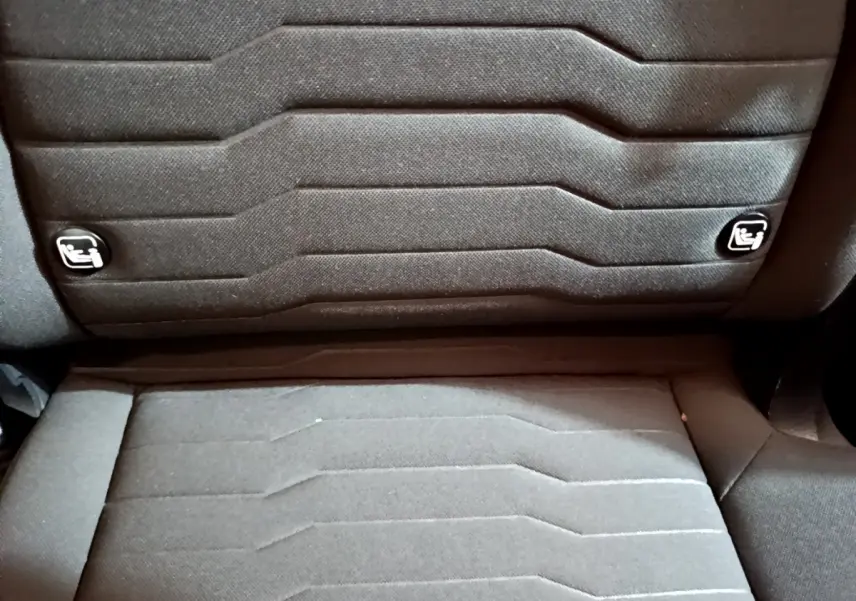 Gros plan sur la banquette arrière noire du Kia Sportage 2022 avec logos Isofix visibles sur les dossiers.