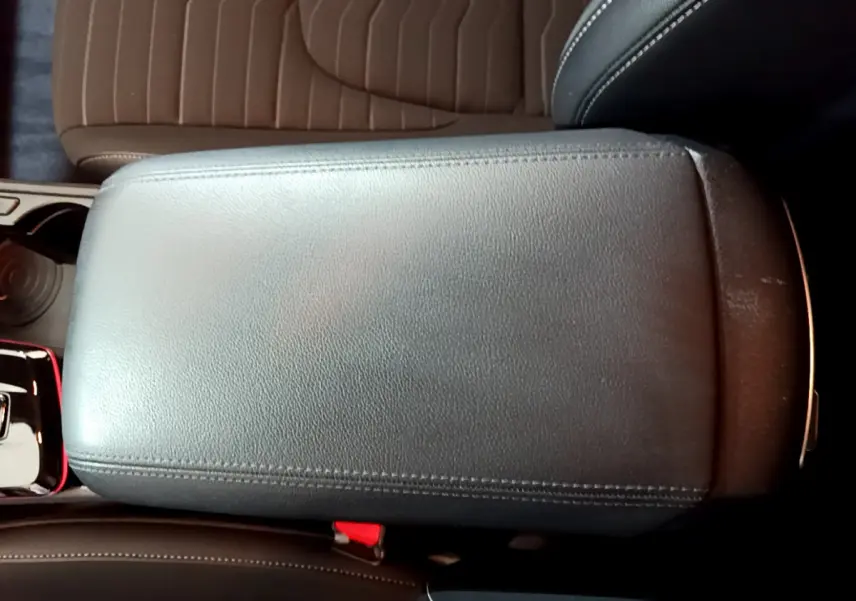 Vue rapprochée de l'accoudoir central en cuir noir du Kia Sportage hybride rechargeable blanc 2022.