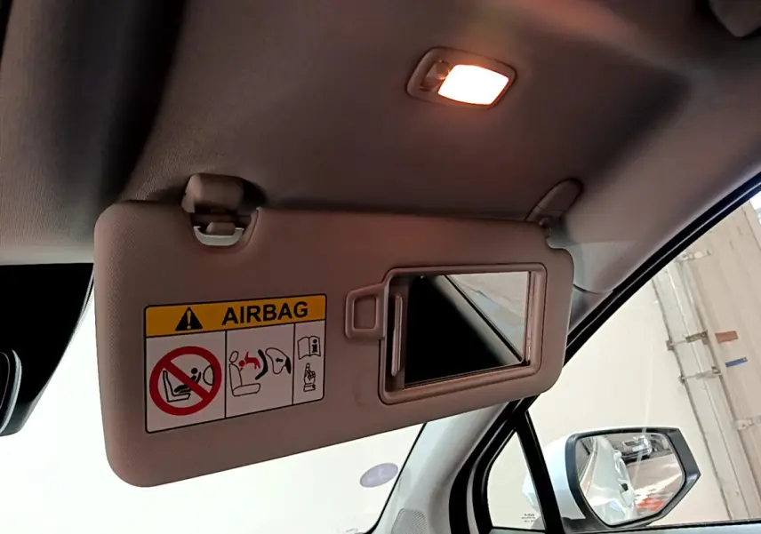 Détail du pare-soleil côté conducteur avec miroir ouvert dans l'habitacle du Kia Sportage blanc 2022.