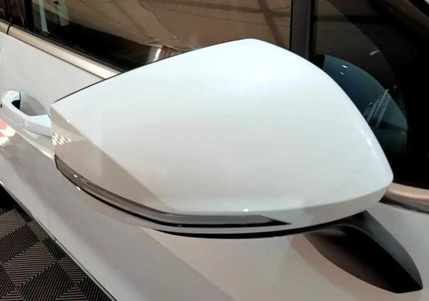 Gros plan sur le rétroviseur droit blanc du KIA SPORTAGE 2022 hybride rechargeable avec clignotant intégré.