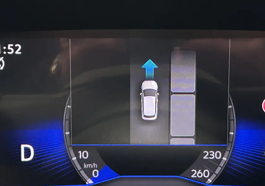 Affichage numérique du tableau de bord du Volkswagen T-Roc gris Indium, montrant la vitesse et l'assistance au stationnement en marche avant.