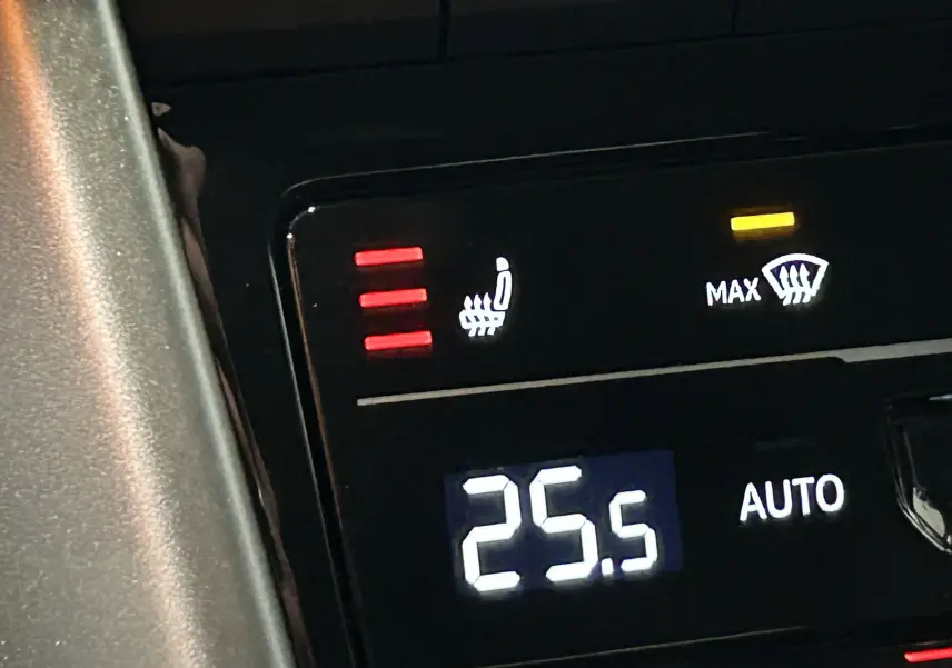 Gros plan sur le panneau de commande intérieur du Volkswagen T-Roc 2025, montrant la température à 25,5°C et le siège chauffant activé.