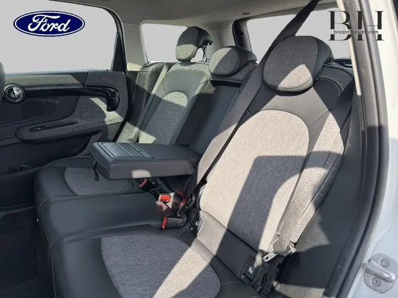 Vue latérale intérieure des sièges arrière gris et noir du MINI Countryman Cooper SE 2021 avec accoudoir central déployé.