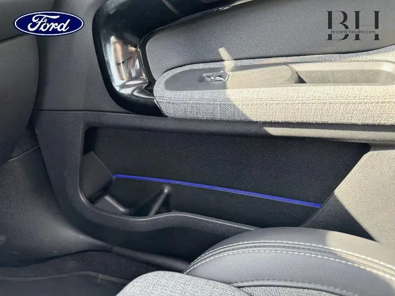 Détail de la porte avant droite du MINI Countryman Cooper SE 2021 en Moonwalk Grey, avec insert décoratif bleu et tissu gris.