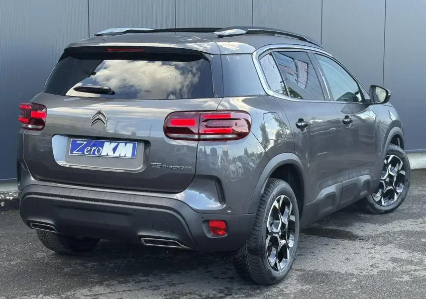 Vue 3/4 arrière droite d'un Citroën C5 Aircross gris Platinium avec jantes alliage et hayon électrique.