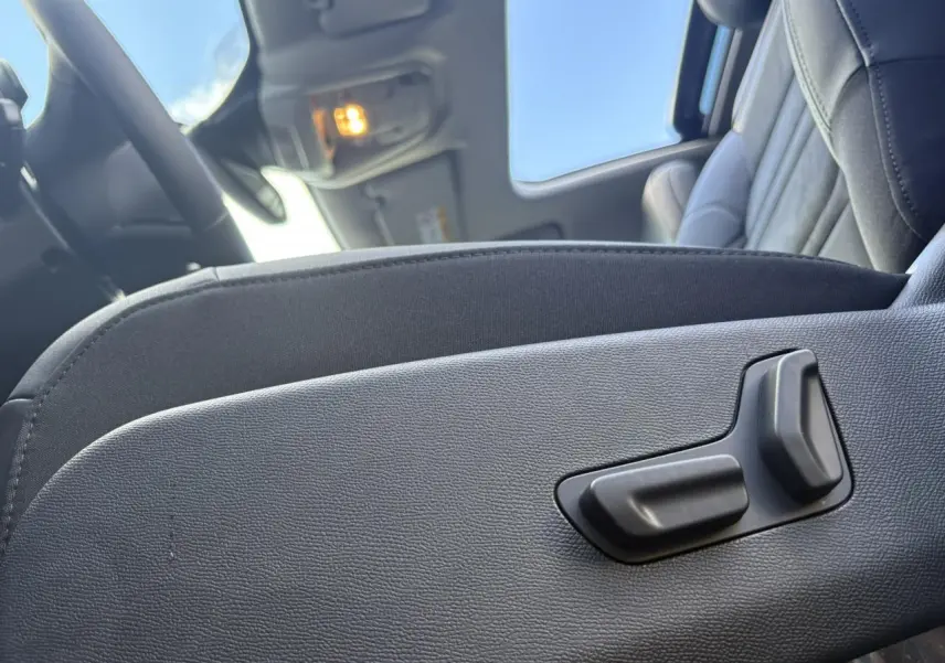 Gros plan sur les commandes électriques du siège conducteur noir Alcantara dans l'habitacle du Citroën C5 Aircross 2025.