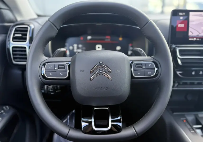Volant en cuir noir de Citroën C5 Aircross 2025, vue frontale avec commandes intégrées et tableau de bord numérique.