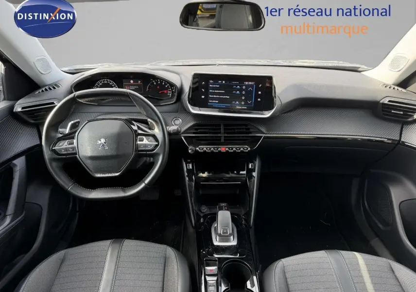 Vue intérieure frontale du tableau de bord et volant noir du Peugeot 2008 gris Artense avec écran tactile central et console brillante.