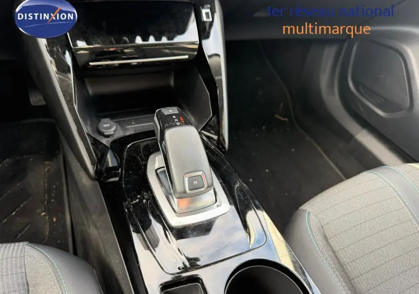 Gros plan sur la console centrale avec levier de vitesse automatique d’une Peugeot 2008 gris Artense, intérieur tissu et cuir noir.