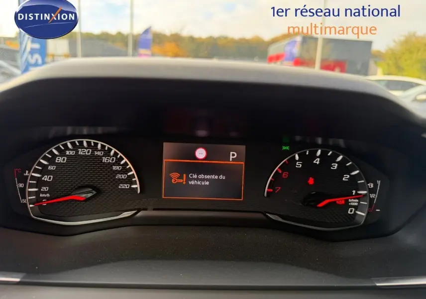 Vue rapprochée du tableau de bord du Peugeot 2008 gris Artense, affichant le compteur et un message d'alerte clé absente.