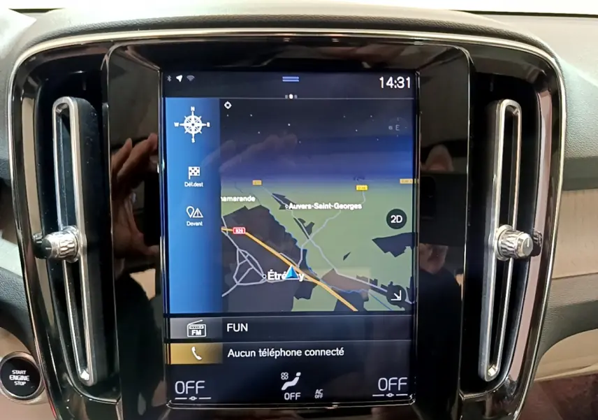 Écran tactile central du tableau de bord du Volvo XC40 noir, affichant la navigation et commandes climatisation.