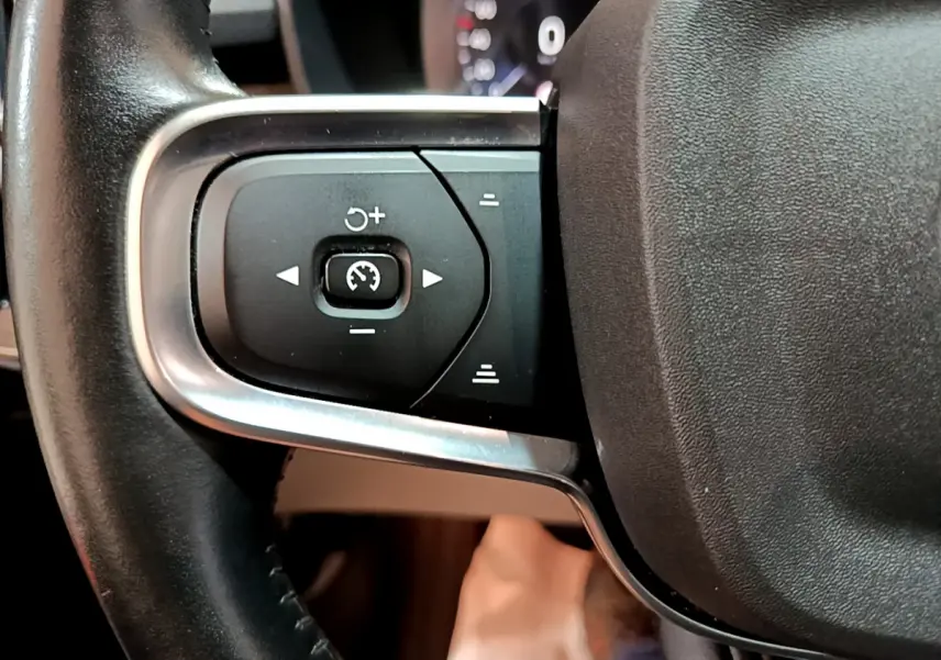 Gros plan sur les commandes de régulateur de vitesse au volant cuir noir du Volvo XC40 T3 Inscription 2020.