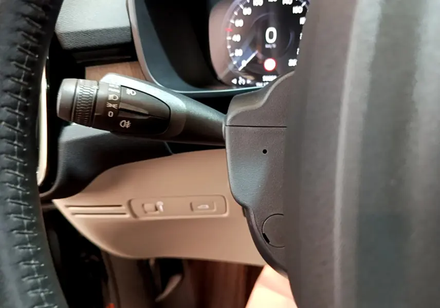 Détail du commodo d'éclairage à gauche du volant cuir noir dans l'habitacle du Volvo XC40 T3 2020.