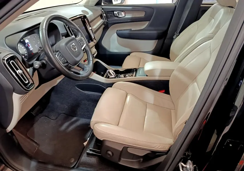 Intérieur beige clair du Volvo XC40 T3 2020 vu côté conducteur, avec tableau de bord et volant multifonctions en cuir.