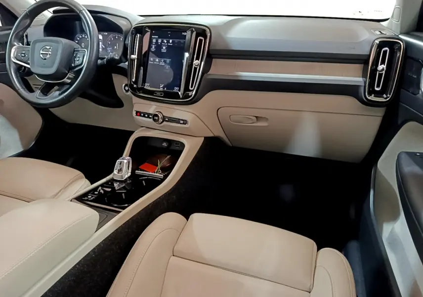 Intérieur clair du Volvo XC40 T3 2020 vu côté passager, avec tableau de bord moderne et écran tactile vertical.
