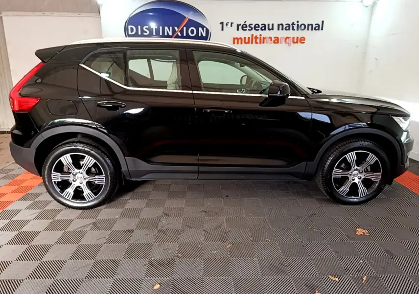 Profil côté gauche d'un Volvo XC40 T3 noir 2020 avec jantes alliage et toit contrasté blanc dans un showroom.