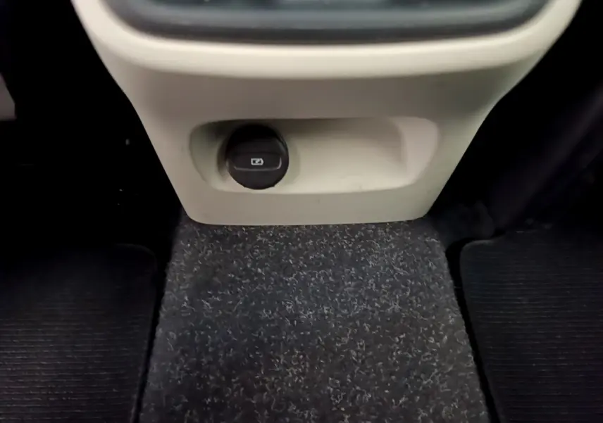 Prise 12V noire sous la console centrale beige, vue intérieure du plancher du Volvo XC40 T3 noir 2020.