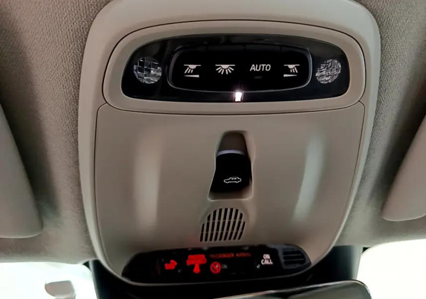 Vue rapprochée du plafonnier beige avec commandes d’éclairage et ouverture du coffre dans un Volvo XC40 noir 2020.
