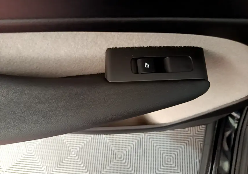 Détail de la commande de lève-vitre côté conducteur sur la porte intérieure beige et noire du Volvo XC40 T3 noir 2020.