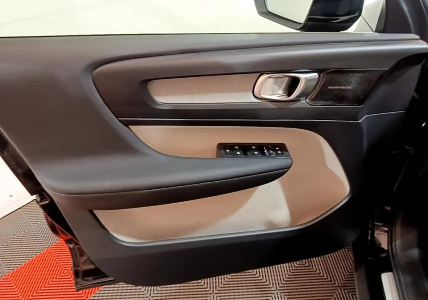 Panneau de porte côté gauche noir et beige du Volvo XC40 T3 2020 avec commande des vitres et haut-parleur Harman Kardon visible.