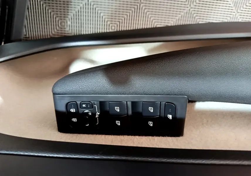 Commandes des vitres et rétroviseurs sur la porte côté conducteur d'un Volvo XC40 T3 noir, intérieur beige et noir.