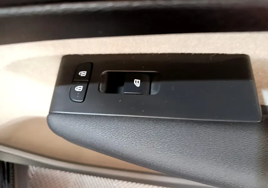 Gros plan sur les commandes de verrouillage et lève-vitre côté conducteur du Volvo XC40 T3 noir, intérieur beige.