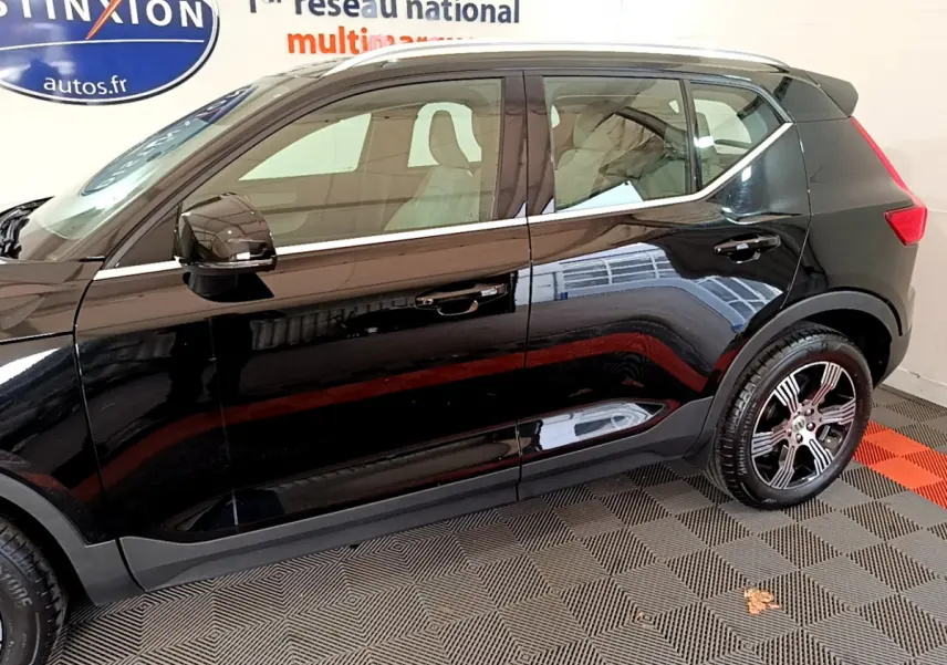 Profil côté gauche du Volvo XC40 T3 noir 2020 avec jantes alliage et vitres teintées en intérieur showroom.