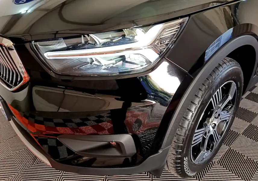 Gros plan sur l'avant droit noir du Volvo XC40 T3 2020, mettant en valeur le phare LED et la roue à jante noire.