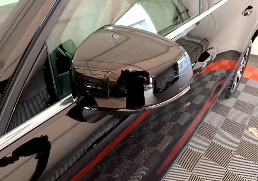 Rétroviseur côté gauche noir brillant du Volvo XC40 T3 2020, avec reflet d'intérieur de garage visible.