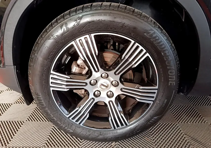 Gros plan sur la jante alliage noir et argentée d'un Volvo XC40 T3 2020, avec pneu Bridgestone visible.