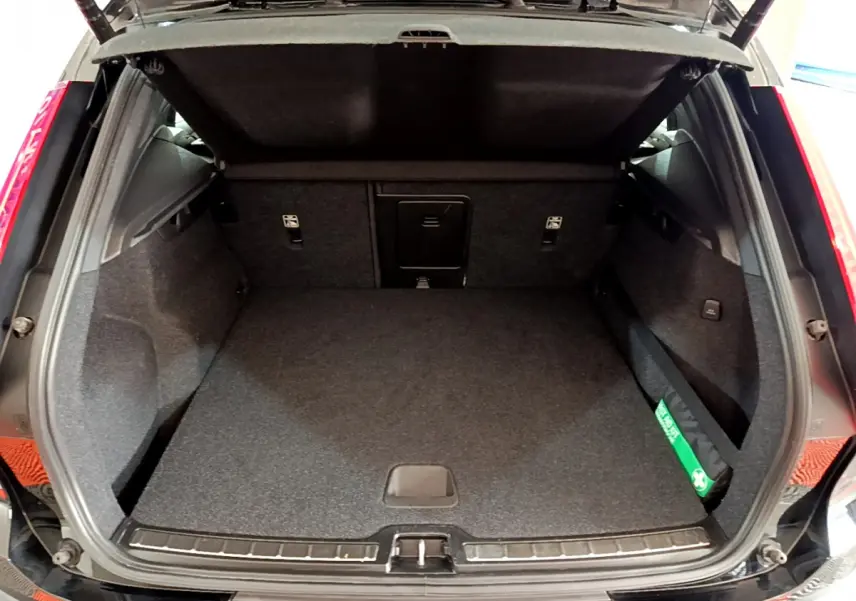 Coffre ouvert noir d’un Volvo XC40 T3 2020, montrant un espace de chargement propre et spacieux.