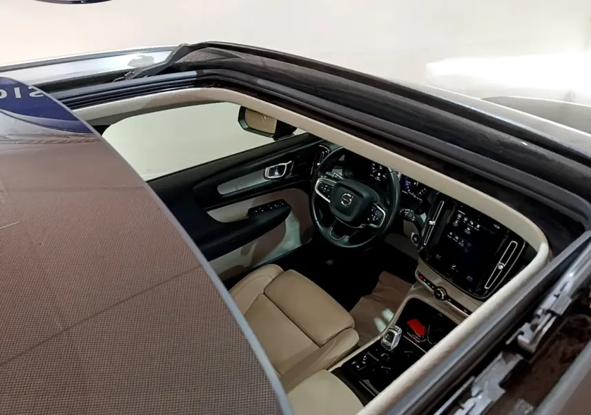 Vue plongeante sur l'intérieur beige et noir d'un Volvo XC40 T3 2020 avec toit ouvrant panoramique noir.