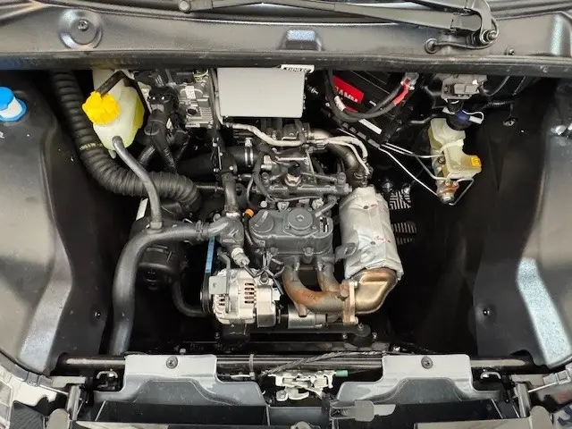 Vue plongeante sur le moteur diesel d’une Aixam Ambition 0.5 City Pack gris foncé, montrant les composants mécaniques.