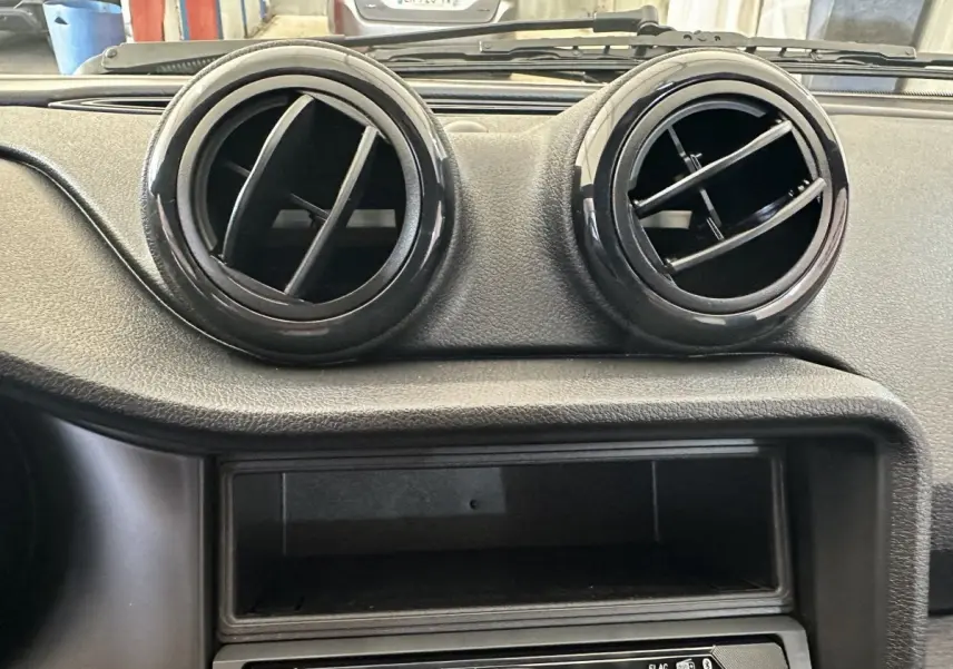 Détail intérieur montrant les deux aérateurs ronds noirs du tableau de bord de l'AIXAM AMBITION 0.5 CITY PACK 2026.