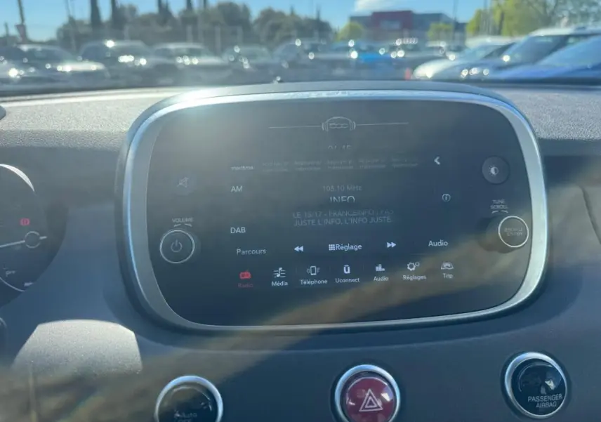 Vue rapprochée de l’écran tactile central du tableau de bord du Fiat 500X bleu, affichant les réglages audio.
