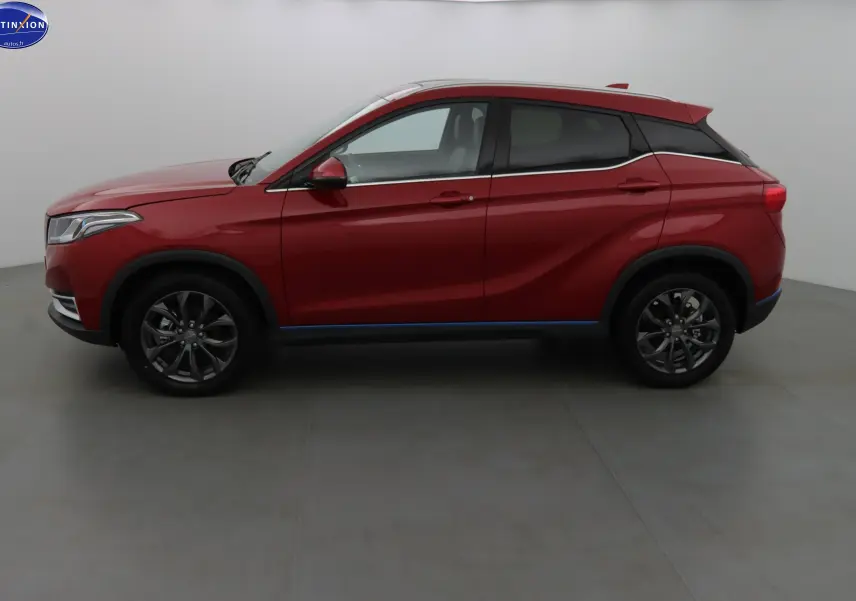 Vue de profil côté gauche du SUV électrique SERES 3 rouge solaire métal avec jantes alliage et lignes dynamiques.