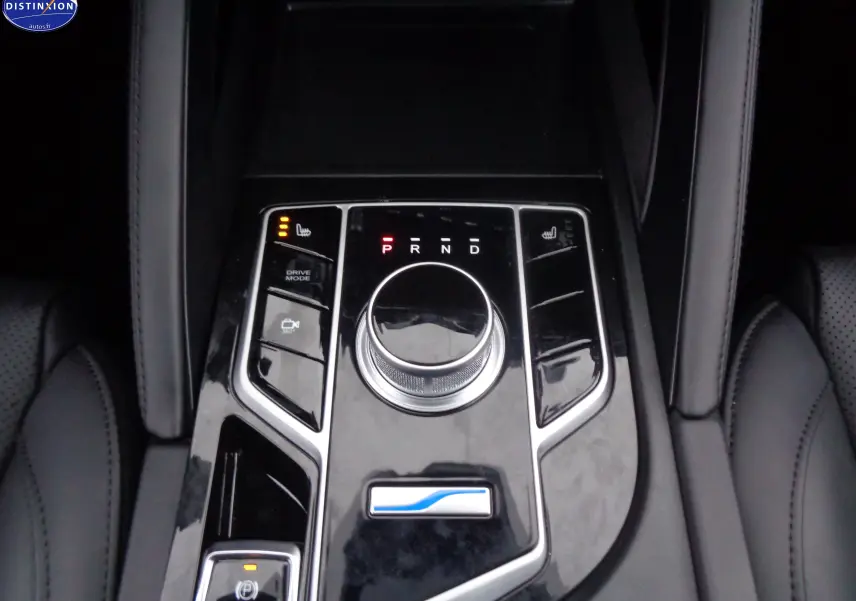 Gros plan sur la console centrale noire brillante du SERES 3 électrique avec molette de boîte auto et commandes chauffantes.