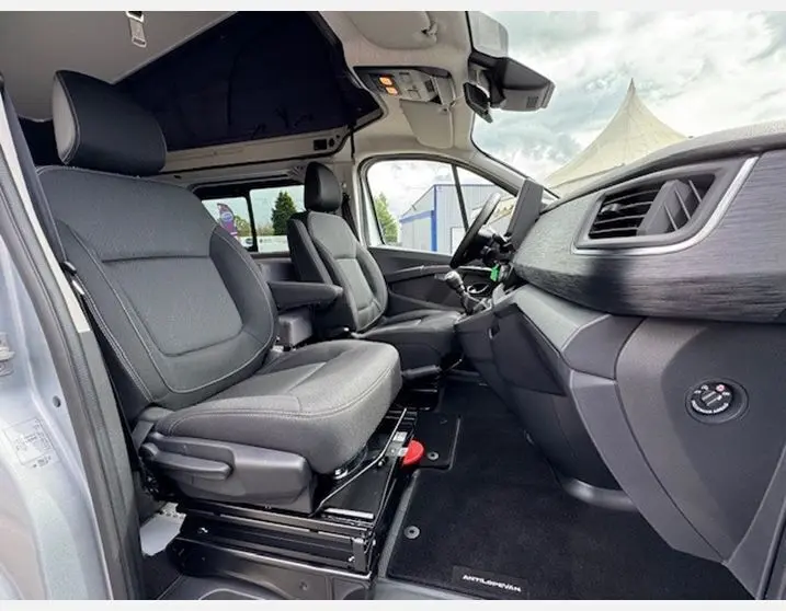 Vue intérieure côté conducteur du Renault Trafic Fourgon Antilope Van Flex Plus 2025, sièges pivotants et planche de bord noir titane.