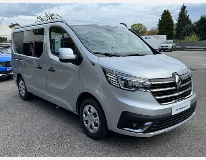Renault Trafic Fourgon gris Highland en 3/4 avant droit, avec vitres latérales surteintées et feux LED distinctifs.