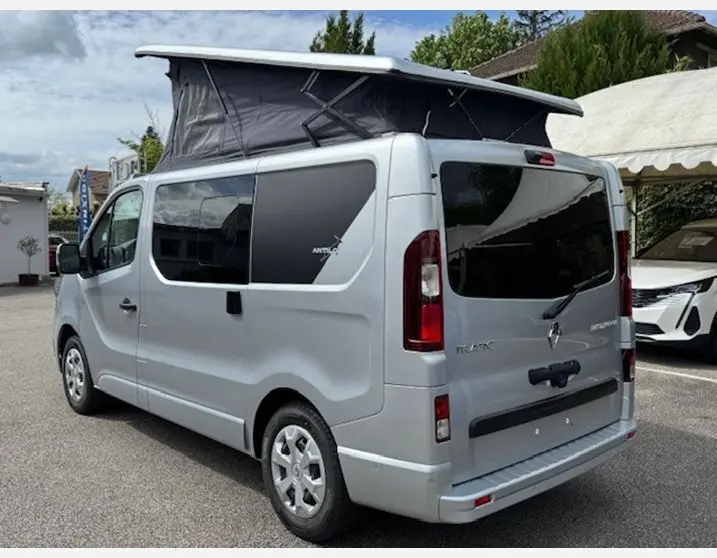 Vue 3/4 arrière droite du Renault Trafic Fourgon Antilope gris Highland avec toit relevable déployé et vitres surteintées.