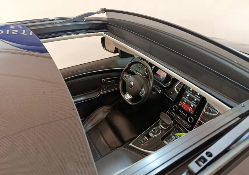 Vue intérieure côté conducteur du Renault Espace noir 2018, volant cuir, écran tactile central et toit ouvrant panoramique visible.