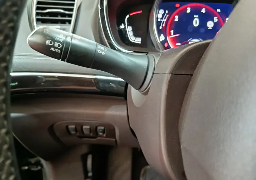 Gros plan sur la manette de clignotant et le tableau de bord numérique rouge du Renault Espace noir 2018.