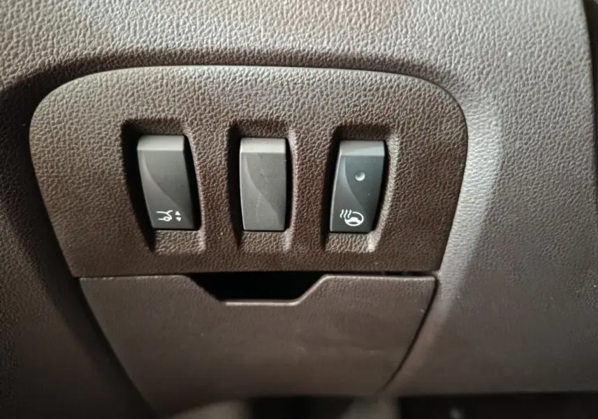 Gros plan sur les commandes noires en plastique intégrées au tableau de bord marron du Renault Espace Initiale Paris 2018.