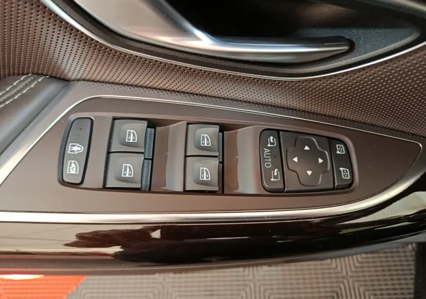 Gros plan sur les commandes des vitres et rétroviseurs côté gauche d'une Renault Espace noire, finition Initiale Paris.