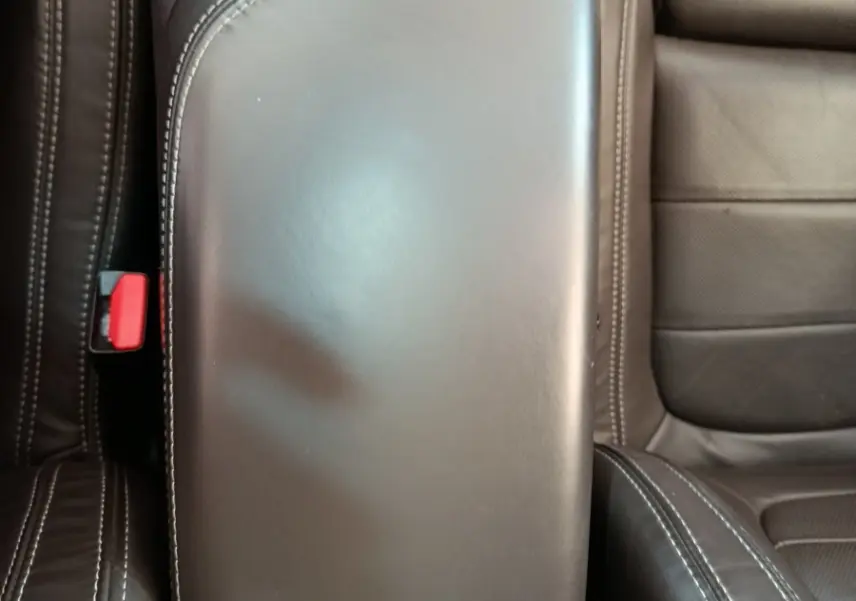 Accoudoir central en cuir noir avec surpiqûres blanches, entre les sièges avant du Renault Espace noir 2018.